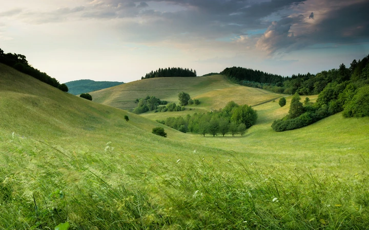 Eco-Friendly Adventures — Green Travel with Positive Impact Breathtaking panoramic view of lush green rolling hills and valleys showcasing pristine eco-friendly sustainable travel destinations